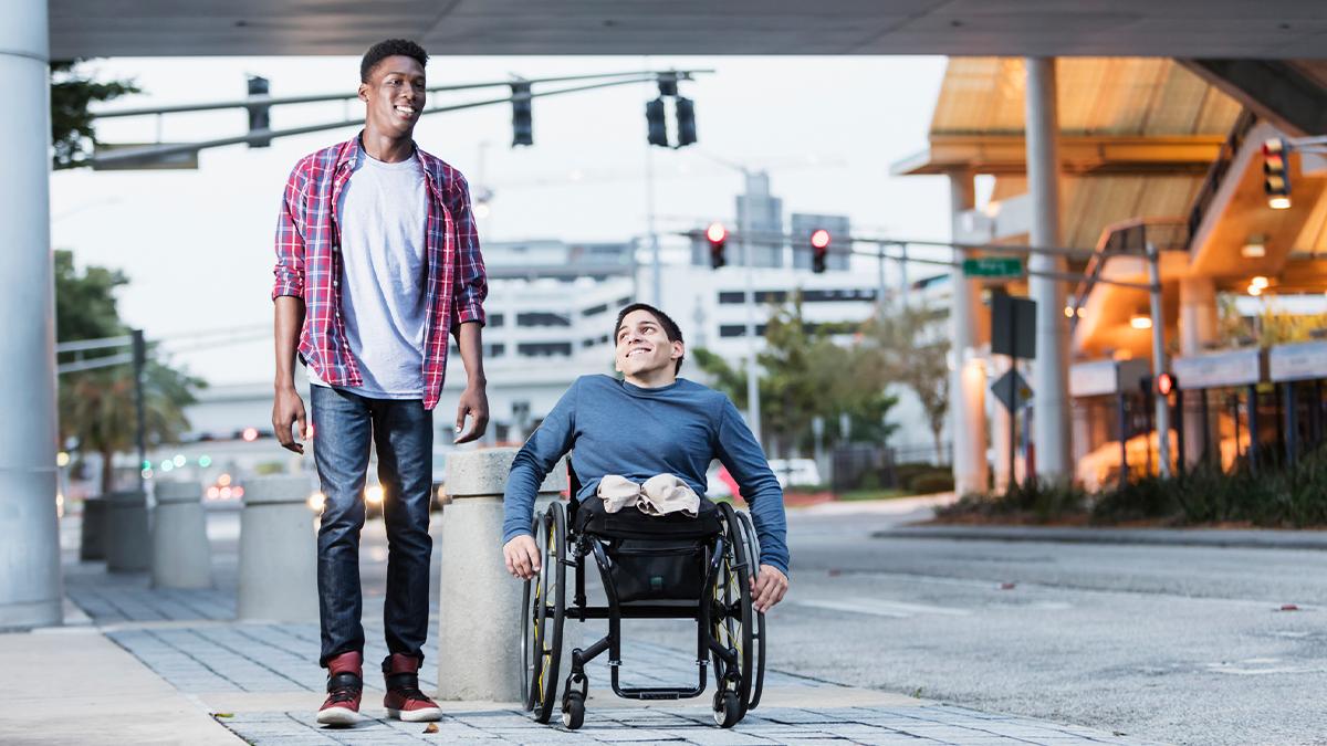 Two young men talking together on a city sidewalk